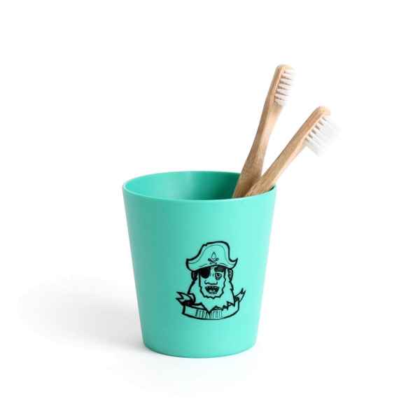 Zwei Bambuszahnbürsten in einem grünen Becher mit Piratenmotiv.