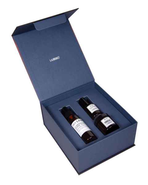 Offene blaue Geschenkbox mit zwei braunen Flaschen von LA:BRUKET Pflegeprodukten.