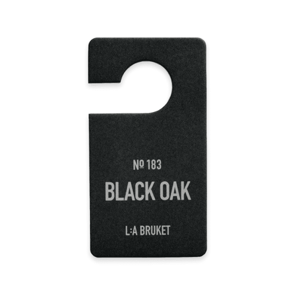 Schwarzer Duftanhänger von L:A Bruket mit der Aufschrift 'No 183 Black Oak'.