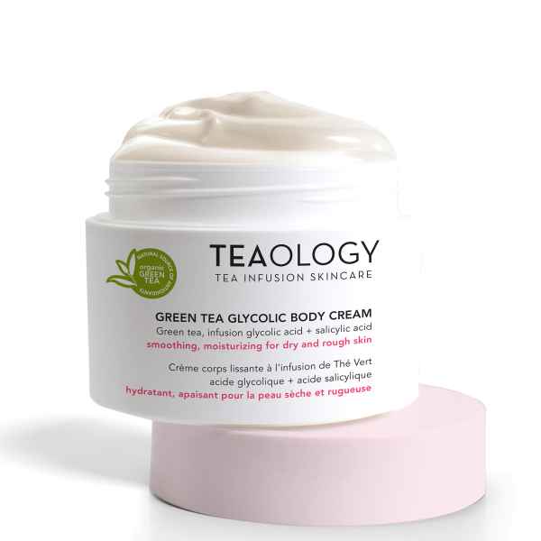 TEAOLOGY Green Tea Glycolic Body Cream auf rosa Sockel, feuchtigkeitsspendend und glättend für trockene und raue Haut.