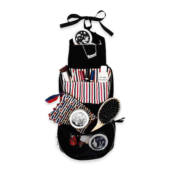 Hängende Kosmetiktasche mit verschiedenen Pflegeprodukten, Bürste und Make-up-Accessoires.