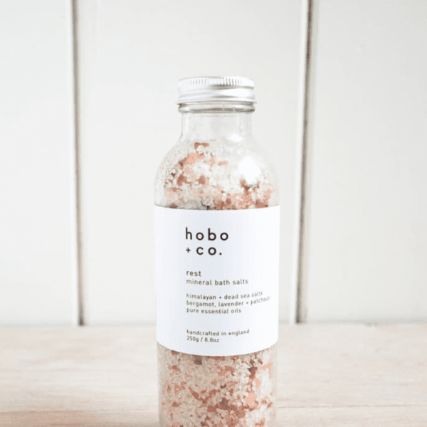 Eine Flasche hobo+co Rest Mineral Bath Salts auf einem Holztisch.