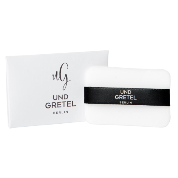 UND GRETEL ILGE Translucent Compact Powder Puff vor weißem Hintergrund, mit schwarzem Band und Verpackung.