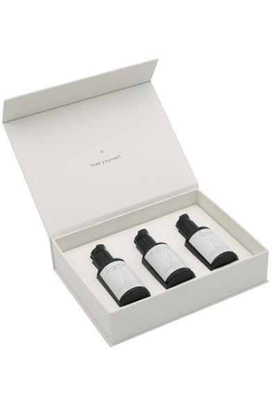 Offene weiße Box mit drei schwarzen Flaschen, beschriftet mit 'love yourself'.