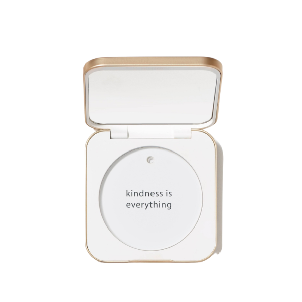 Geöffnete weiße Puderdose mit goldenen Akzenten und der Aufschrift 'kindness is everything'.
